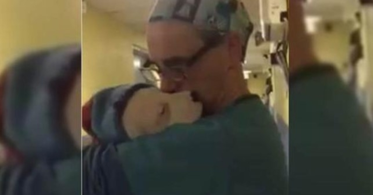 Tierarzt wiegt den verängstigten und weinenden Rettungshund nach der Operation wie ein Baby